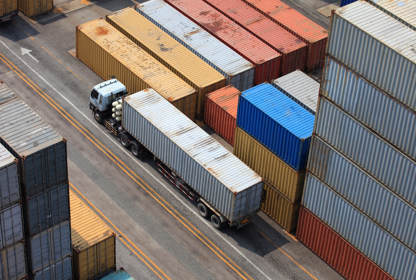 Aerial view of a truck moving between container stacks